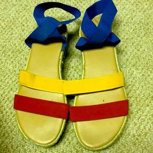 Blue,red,and yellow sandals with a blue and white foam heal